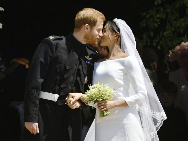 Prince Harry and Meghan Markle kiss on the steps of St George's Chapel in Windsor. Picture: Ben Birchhall/pool photo via AP.