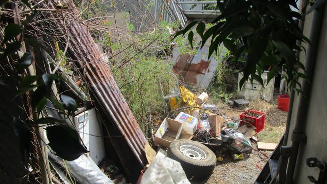 Fencing materials, tyres, rubbish and more collected in a yard.