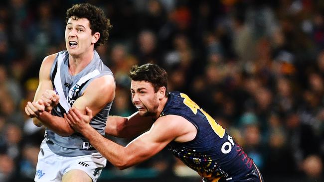 Darcy Byrne-Jones fires out a handpass under pressure from Adelaide’s Rory Atkins in Showdown 46. Picture: Mark Brake/Getty,