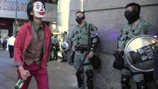 A man in Halloween costume walks past riot police in Hong Kong, as authorities brace for more rallies testing the government ban on face coverings. Picture: AP Photo