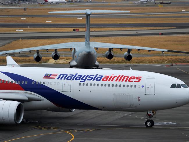 PERTH, AUSTRALIA - MARCH 25: A Malaysia Airlines plane prepares to go out onto the runway and passes by a stationary Chinese Ilyushin 76 aircraft (top) at Perth International Airport on March 25, 2014 in Perth Australia. The Australian Maritime Safety Authority has suspended the air and sea search for the missing Malaysian Airlines flight MH370 due to poor weather conditions in the search area. Search operations are expected to resume tomorrow. (Photo by Greg Wood - Pool/Getty Images)