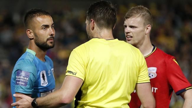 Referee Shaun Evans speaks to Mark Birighitti of the Mariners and Jordan Elsey of Adelaide during the FFA Cup Semi Final in Gosford this month. Picture: AAP Image/Darren Pateman