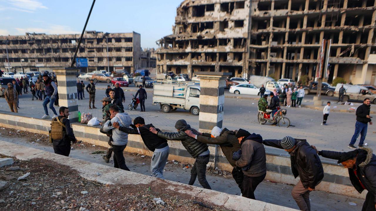 Syrian rebel fighters parade detained members of the Syrian government's forces in civilian clothing in Homs. Picture: Aaref Watad/AFP