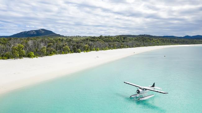 Aerial photo of seaplane next to Whitehaven Beach on Whitsunday Island. Picture: Brooke Miles for Riptide Creative