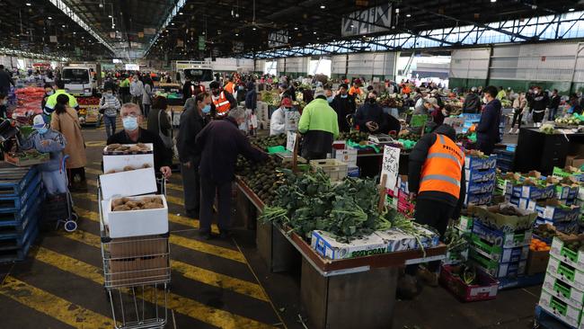 People at Flemington Markets on Saturday. Health authorities are urging people in western and southwestern suburbs to be on the look out for symptoms. Picture: Tim Hunter.