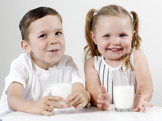 Hudson, 5, and Harlow Mulqueen, 2, posing while drinking milk at their home in Bulimba, Brisbane 3rd of January 2020.  Kids who drink full-cream milk are healthier.  (AAP Image/Josh Woning)