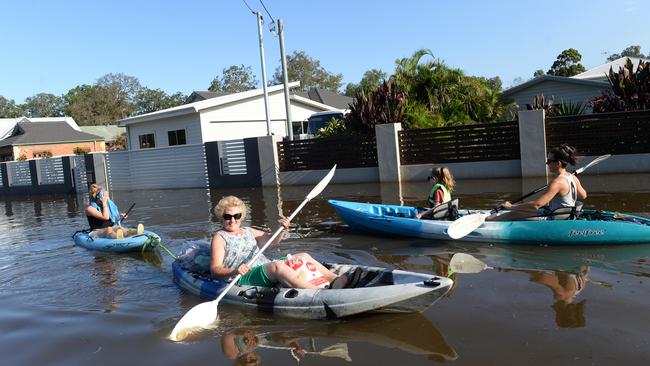 Residents whose Chittaway Bay street was swamped by flood waters travelled down the road in kayaks and canoes. Picture: Jeremy Piper