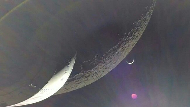 Earth is visible as a crescent in the minutes after Orion finished its engine burn around the moon on Monday. Picture: NASA/AFP