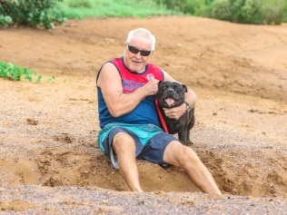 Tom Cummins with staffy Banjo who returned to the beach after surviving a crocodile attack. Picture: Glenn Campbell