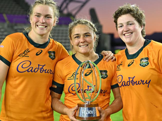 Dinnen with Kaitlan Leaney (L) and Bridie O’Gorman (R) celebrating victory for the Wallaroos. Picture: Johan Rynners – World Rugby/World Rugby via Getty Images
