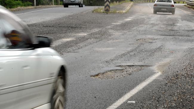 Drivers are forced to negotiate deep potholes near the exit ramp to Maryborough off the Bruce Highway. Photo: Karleila Thomsen / Fraser Coast Chronicle