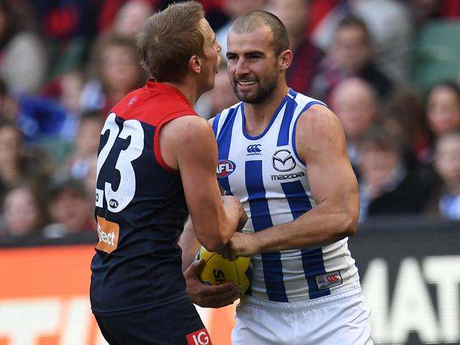 Ben Cunnington of the Kangaroos (right) punches Bernie Vince of the Demons in the stomach during the Round 9 AFL match between the Melbourne Demons and the North Melbourne Kangaroos at the MCG in Melbourne, Sunday, May 21, 2017. (AAP Image/Julian Smith) NO ARCHIVING, EDITORIAL USE ONLY