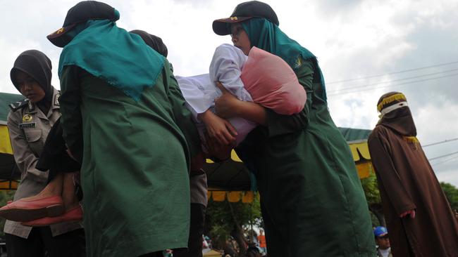 She is carried by officials after being caned in public. Picture: Chaideer Mahyuddin