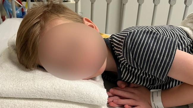 A sick four-year-old boy lies on towels after a nurse at the WCH couldn’t find a spare pillow in the entire hospital. Picture: Supplied