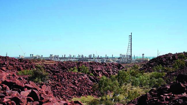 An outcrop of rocks with engravings at Climbing Man Valley, on the Burrup peninsula, near industry.