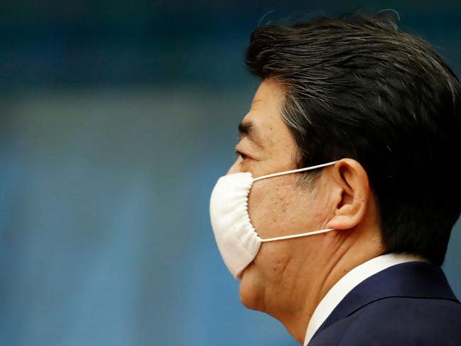 Japan Prime Minister Shinzo Abe wears a face mask as he enters a venue for his news conference in Tokyo yesterday. Picture: AFP