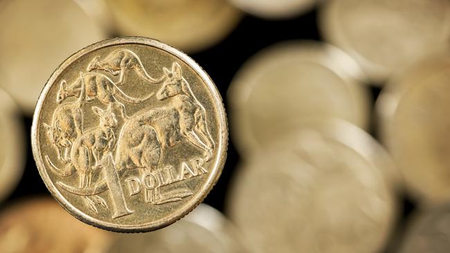 Australian one dollar coin over blurred golden background.