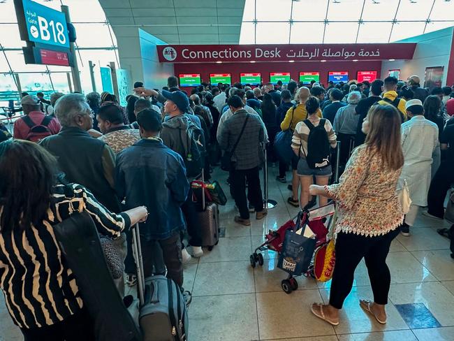 Passengers queue at a flight connection desk at the Dubai International Airport in Dubai on April 17, 2024. Dubai's major international airport diverted scores of incoming flights on April 16 as heavy rains lashed the United Arab Emirates, causing widespread flooding around the desert country. Dubai, the Middle East's financial centre, has been paralysed by the torrential rain that caused floods across the UAE and Bahrain and left 18 dead in Oman on April 14 and 15. (Photo by AFP)