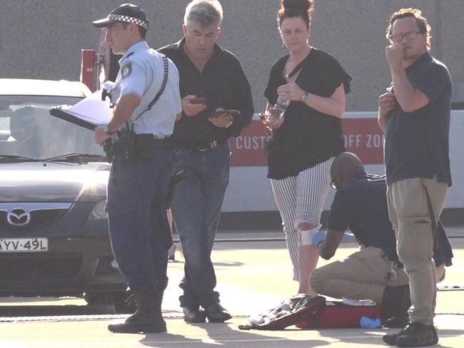 A woman is treated at the scene where a Porsche was allegedly car at Eastgardens shopping centre on Monday. Picture: TNV