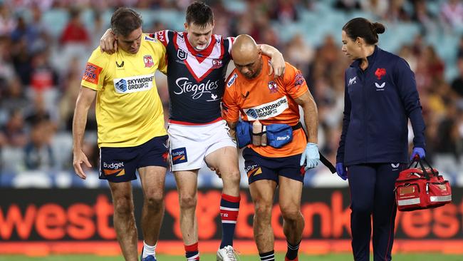 Luke Keary of the Roosters is helped off the field