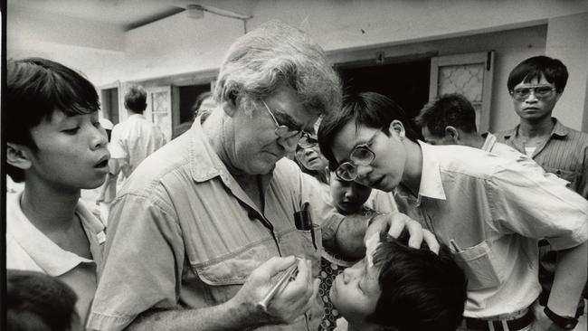 A photo of the late Professor Fred Hollows treating a boy in Vietnam. Photo: Michael Amendolia