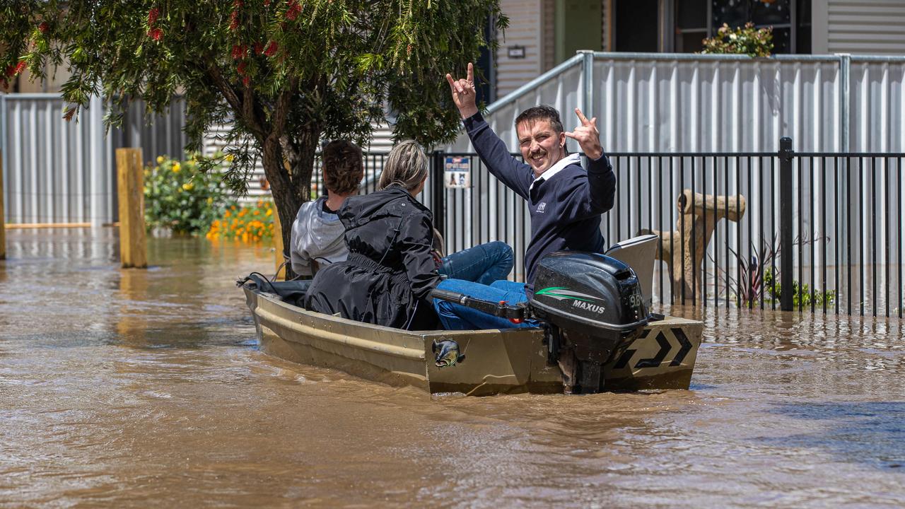 Residents flee their flooded Rochester home in a tinny. Picture: Jason Edwards