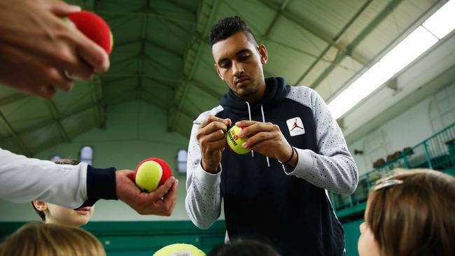 Nick Kyrgios signs autographs while preparing for the Queen’s Club tournament.