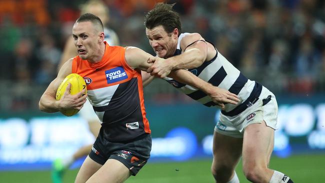 Tom Scully is tackled by Patrick Dangerfield in the Round 15 draw at Spotless Stadium. Picture: Phil Hillyard