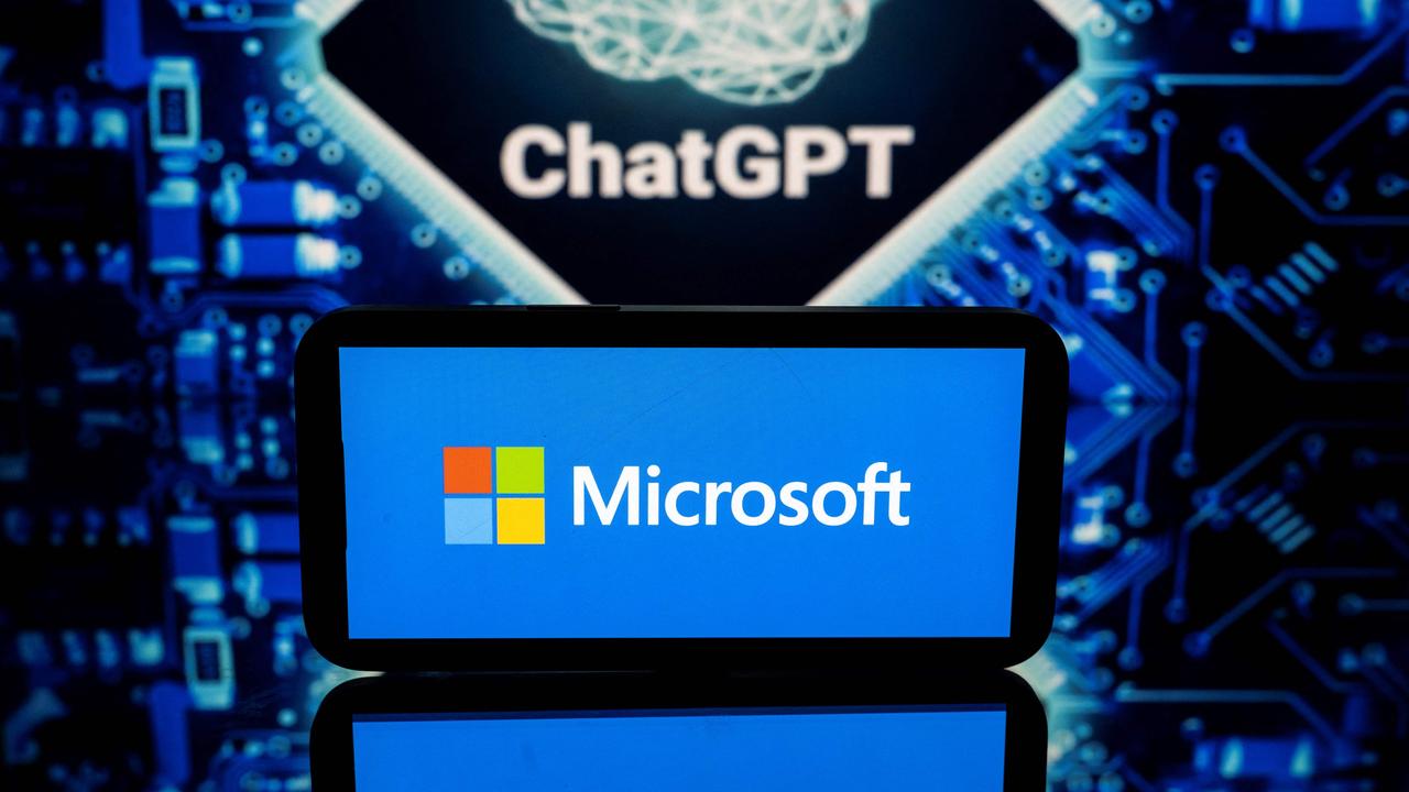 Screens displaying the logos of Microsoft and ChatGPT (Photo by Lionel BONAVENTURE / AFP)