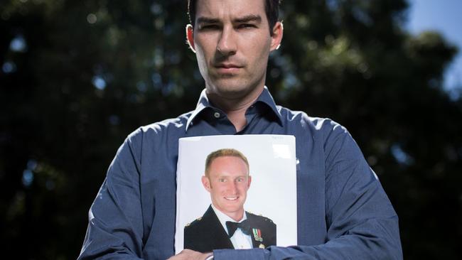 19/02/2016: Afghanistan veteran John Bale holds a photo of his fallen friend Lt. Michael Fussell at Parliament House in Canberra. Stefan Postles/The Australian