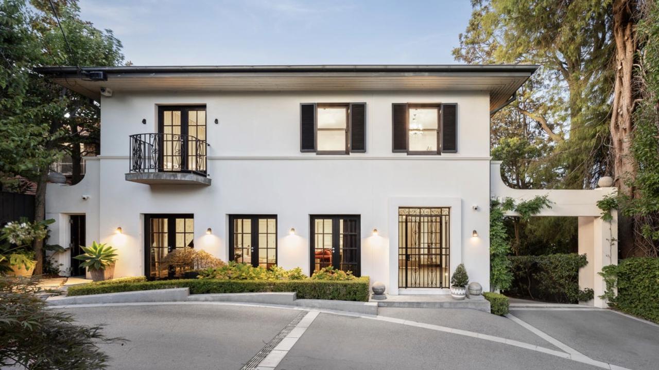 The 1930s Marcus Martin-designed Toorak mansion features a grand facade, sweeping circular driveway and manicured gardens.