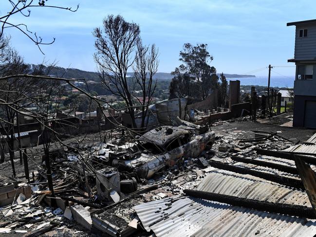 Some of the more than 70 houses and businesses destroyed by a bushfire in the coastal town of Tathra, Monday, March 19, 2018. RFS and NSW Fire and Rescue continue to mop up and douse smouldering homes after a devastating fire ripped through the community yesterday and overnight. (AAP Image/Dean Lewins) NO ARCHIVING