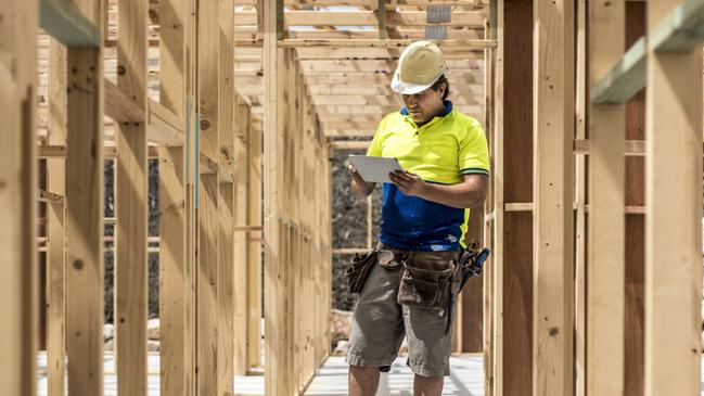 Developing Queensland - Construction worker on construction site, using digital tablet. He is checking if everything is ok.