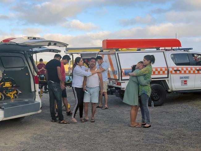 Loved ones comfort each other as the bodies of three drowning victims are taken from the scene at Forrest Caves Phillip Island. Picture: Jack Colantuono