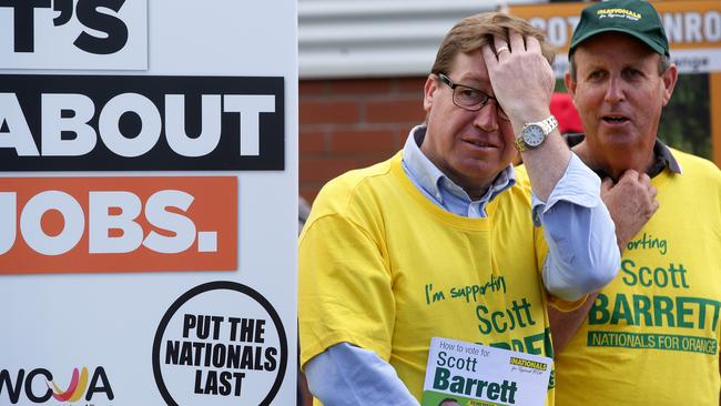 Nationals leader Troy Grant cuts a lonely figure amid a cavalcade of noisy anti-Nationals volunteers at the Bletchington Public School booth for the Orange by-election. Picture: Jonathan Ng