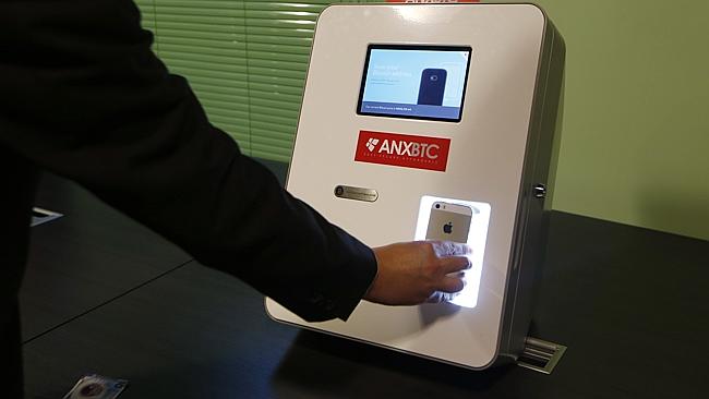 Ken Lo, CEO of ANXBTC Bitcoin Exchange scans his mobile QR code by a Bitcoin ATM. (AP Photo/Kin Cheung)