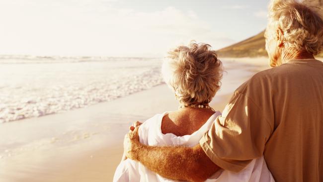 Senior couple embracing on beach, rear viewretirees thinkstockolder couple walking on the beachsuperannuation genericelderly, active, wealth, couple, aging, beach, cancer