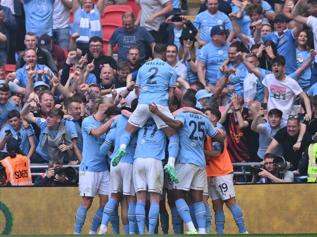 Ilkay Gundogan celebrates with teammates after scoring their second goal. Photo by Glyn KIRK / AFP.