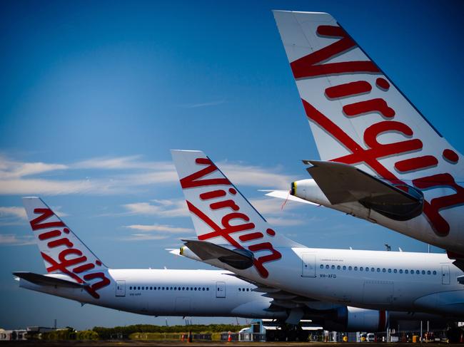 Virgin Australia aircraft are seen parked on the tarmac at Brisbane International airport on April 21, 2020. - Cash-strapped Virgin Australia collapsed on April 21, making it the largest carrier yet to buckle under the strain of the coronavirus pandemic, which has ravaged the global airline industry. (Photo by Patrick HAMILTON / AFP)