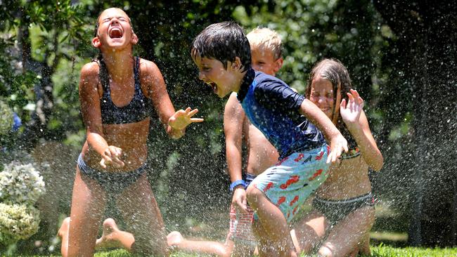 Cooling off with the backyard sprinkle: Alice Hillsdon, Charlie Hardwick, Henry Hillsdon and Fleur Hillsdon. Picture: Nathan Edwards