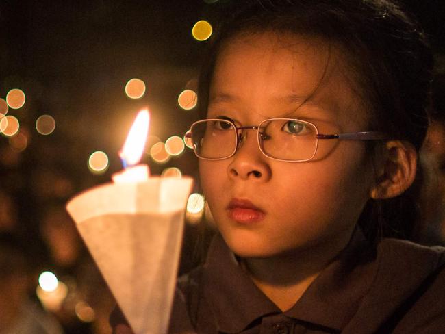 A young girl holds her candle at a vigil in Hong Kong on June 4, 2016, during the commemoration of the bloody Tiananmen Square crackdown in 1989. / AFP PHOTO / ANTHONY WALLACE