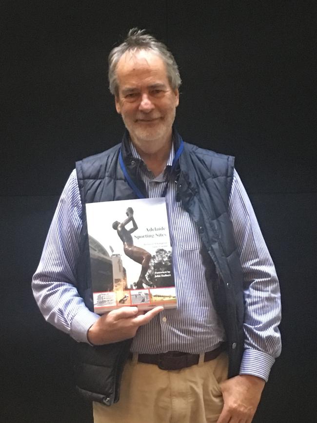 Sport historian Dr Bernard Whimpress with a previous book he has written.