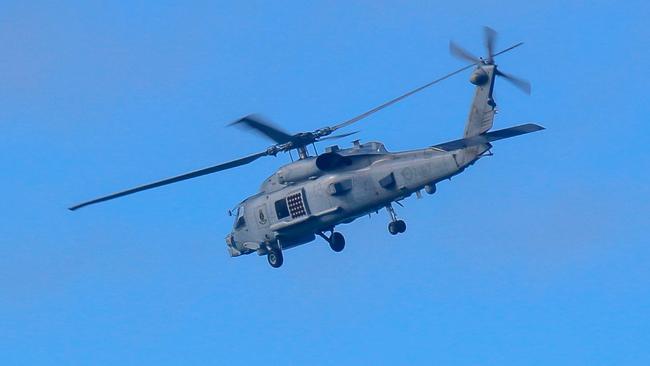 This handout photo taken on July 29, 2023 and received on July 30 from the Australian Defence shows a Royal Australian Navy helicopter conduct search and rescue operations in the vicinity of Lindeman Island, Queensland. Australia's military will ground its fleet of MRH-90 Taipan helicopters after a crash during multinational military exercises that left four crew members missing, the army chief said on July 30. (Photo by AUSTRALIAN DEFENCE / AFP) / ----EDITORS NOTE ----RESTRICTED TO EDITORIAL USE MANDATORY CREDIT " AFP PHOTO / AUSTRALIAN DEFENCE" NO MARKETING NO ADVERTISING CAMPAIGNS - DISTRIBUTED AS A SERVICE TO CLIENTS