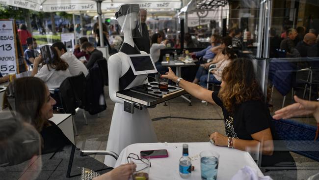 A robot known as “Alexia” waits on customers at a bar at Plaza del Castillo square, in Pamplona, northern Spain on June 5 as lockdown restrictions ease. Picture: AP Photo/Alvaro Barrientos