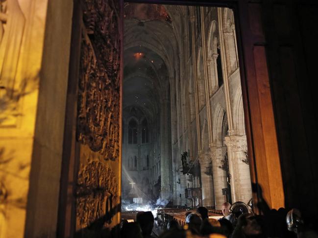 This view from the entrance shows smoke rising in front of the altar cross. Picture: Philippe Wojazer / Pool / AFP 