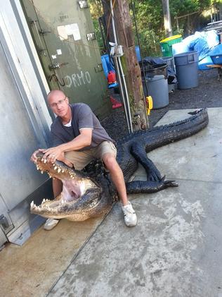 Posing for pics with the slaughtered alligator.