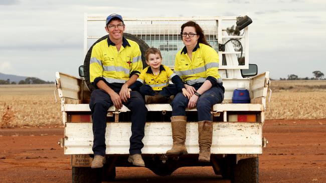 Farmers Mark and Katrina Swift with their son Henry, 4, on the family farm just outside Forbes. Picture: Jonathan Ng