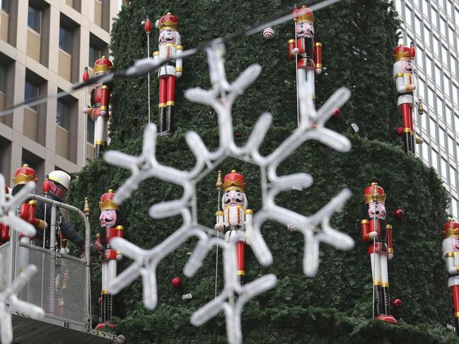 A worker places dolls to decorate a huge Christmas tree in Seoul, South Korea, Thursday, Dec. 6, 2018. Christmas is one of the biggest holidays celebrated in South Korea with some one third of the population being Christians.  (AP Photo/Ahn Young-joon)