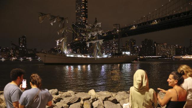 Pedestrians walking along Brooklyn Bridge Park look on as a masted Mexican Navy training ship sits stranded near the Manhattan Bridge after colliding with the Brooklyn Bridge. Picture: AP