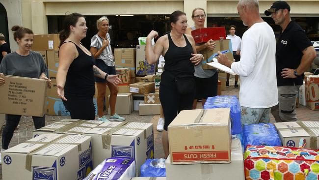 Volunteers sort donation boxes ready to be loaded onto a truck at Bondi Surf Bathers Life Saving Club which has been inundated with donations after setting up as a bushfire relief centre. Picture: John Appleyard